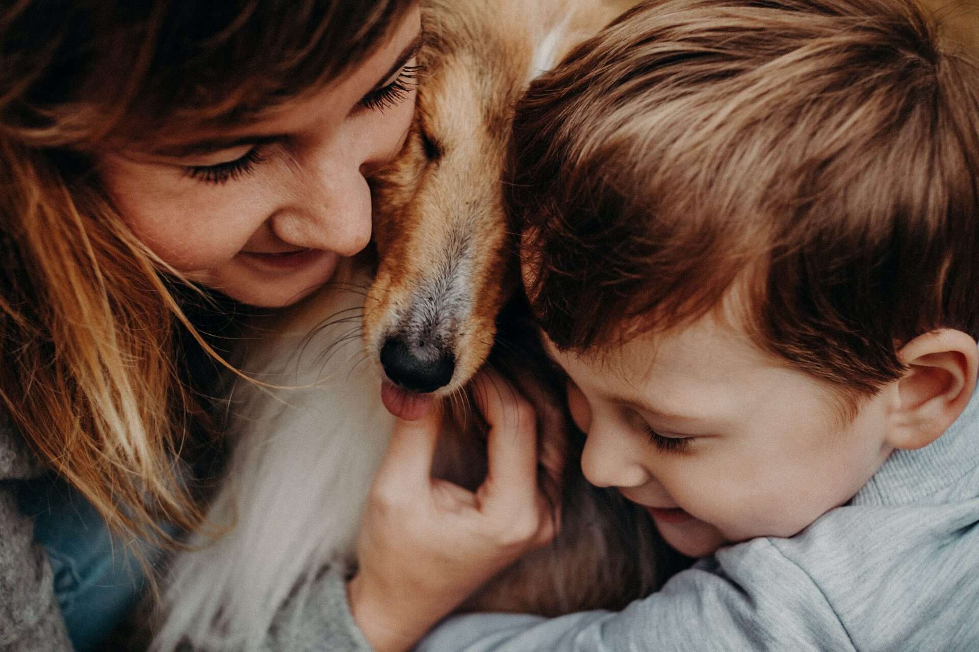 Mum and child cuddling dog