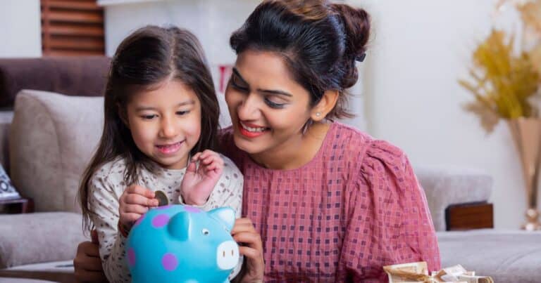 money saving tips - mum and daughter saving into piggy bank