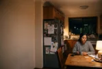 mum at the kitchen table at night with a cup of tea wondering how to know if her marriage is over